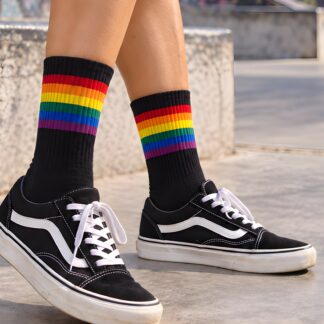Black crew socks with red, orange, yellow, green, blue and purple stripes, worn with black skate shoes